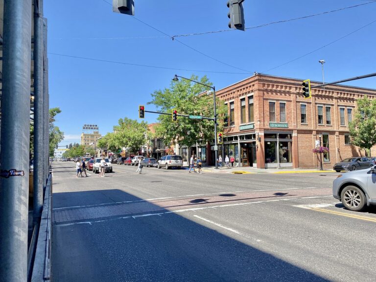 Historic brick storefronts and crosswalk on Main Street in downtown Bozeman, Montana, on a summer day