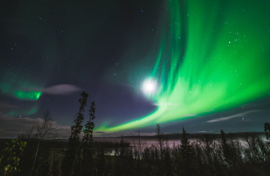 Dazzling aurora borealis illuminating a starry night sky over a serene landscape.