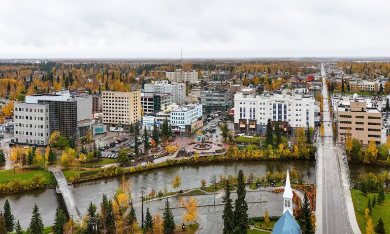 Aerial view of downtown Fairbanks, Alaska, with the Chena River and Cushman Street bridge in autumn