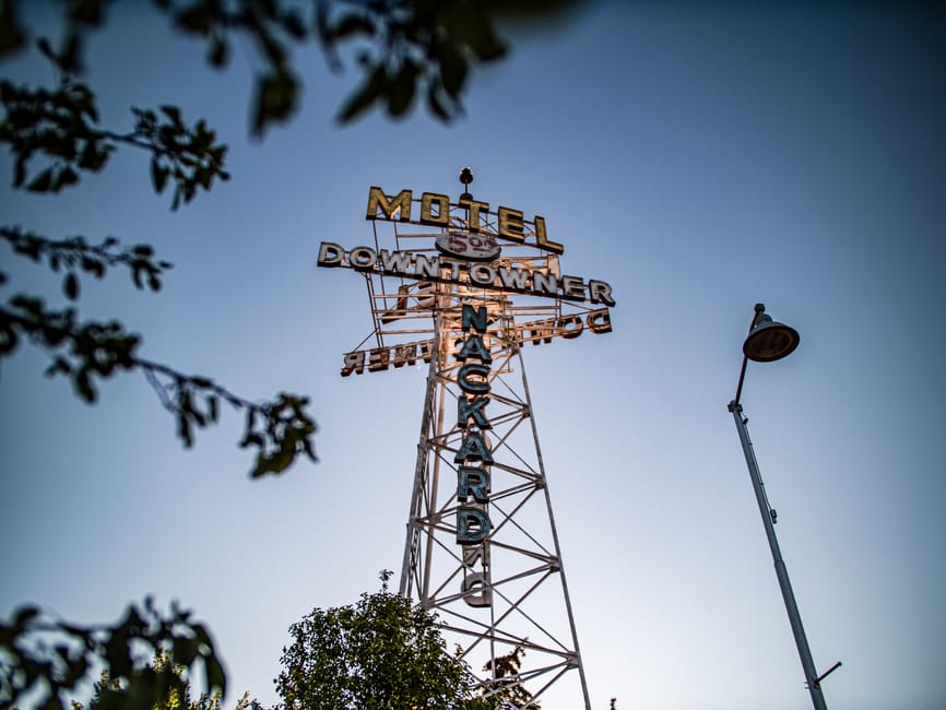 Iconic Downtowner Motel sign in Flagstaff, Arizona against a clear blue sky.