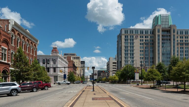 Commerce Street in downtown Montgomery, Alabama, with historic brick storefronts on the left and the Renaissance hotel tower on the right