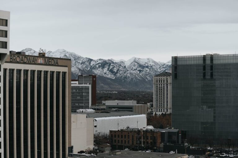 Salt Lake City's urban skyline with snow-capped mountains in the background.