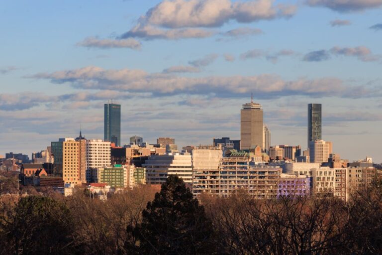 Skyline view of Cambridge, Massachusetts with Boston cityscape in the background under a clear sky.