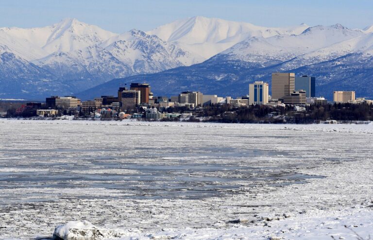 Downtown Anchorage, Alaska, seen across ice on Cook Inlet with the snow-covered Chugach Mountains behind