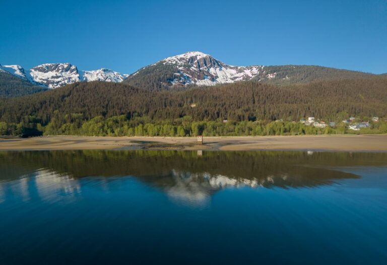 Breathtaking view of snow-capped mountains and serene lake reflections in Juneau, Alaska.