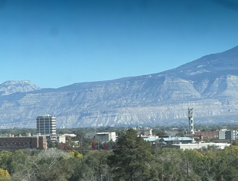 Downtown Grand Junction, Colorado, with office buildings in front of pale desert cliffs under a clear sky
